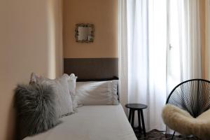 a bedroom with a bed with white pillows and a window at House of Frames in Milan