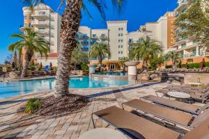 a resort pool with chaise lounge chairs and a palm tree at Marina Inn 4-303B in Myrtle Beach