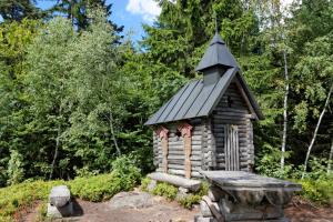a small log cabin with a bench in a garden at Ferienhaus Schachtenbach in Bayerisch Eisenstein