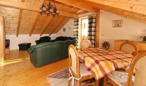 a dining room with a green couch and a table at Ferienhaus Schachtenbach in Bayerisch Eisenstein