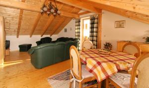 ein Esszimmer mit einem grünen Sofa und einem Tisch in der Unterkunft Ferienhaus Schachtenbach in Bayerisch Eisenstein