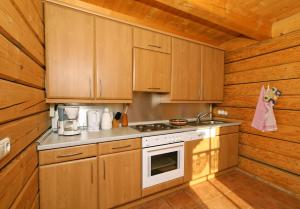 a kitchen with wooden cabinets and a stove at Ferienhaus Schachtenbach in Bayerisch Eisenstein +16 photos