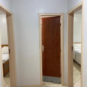 einen Flur mit Tür und Schlafzimmer in der Unterkunft Hotel Sesi Aruana in Aruanã