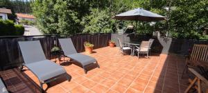 patio con tavolo, sedie e ombrellone di Great place, rural environment a Aránzazu Celaya