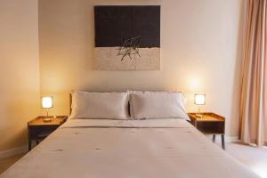 a bedroom with a large white bed with two lamps at Repetita Juvant in Rome
