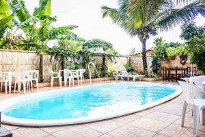 a swimming pool with chairs and a table at Pousada Aconchego Recanto Do Mar - São Sebastião - Caraguatatuba in São Sebastião