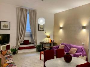 a living room with a purple couch and a table at Chroma Apt Farinone 28 in Rome
