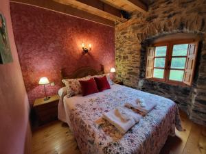 a bedroom with a large bed with towels on it at Hotel Rural LA CÁRCEL in Murias de Paredes