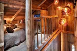 Habitación con cama en una cabaña de madera en CHALET LES CERISES Jacuzzi, Sauna, Hammam, Cinéma, en Cordon