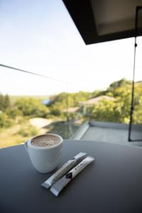 una taza de café y un mando a distancia sobre una mesa en Oliv Residence en Iaşi