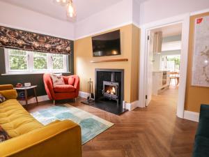 ein Wohnzimmer mit einem Sofa und einem Kamin in der Unterkunft Barn Hoppitt Lodge in London