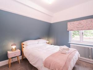 a bedroom with a white bed and a window at Barn Hoppitt Lodge in London