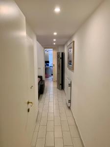 a hallway with a white tile floor and a door at Chroma Apt Farinone 28 in Rome