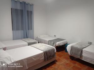 un grupo de 3 camas en una habitación en Casa Barreno en Los Piñuelas