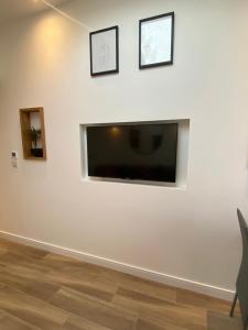 a living room with a flat screen tv on a white wall at Lovely and Modern Studio Apartment. in Borehamwood