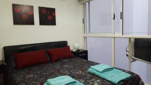 ein Schlafzimmer mit einem Bett mit zwei Handtüchern darauf in der Unterkunft Cheap&Chich Studio in Buenos Aires
