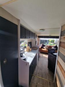 a kitchen with a sink and a living room at Meerblick Wattenmeer ,50m vom Meer,Strand 300m in Westerland