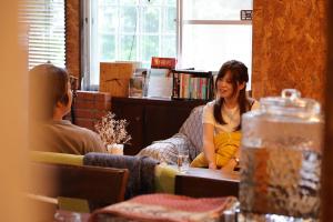 two people sitting at a table in a restaurant at Retopia AIZU磐梯町ゲストハウス 