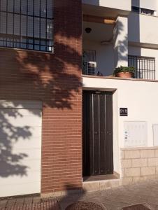 een bakstenen gebouw met een zwarte deur erop bij Apartamento Rauda 51 B, Granada in Granada