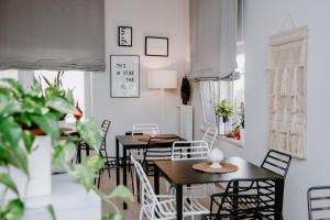 una sala da pranzo con tavoli, sedie e piante di a Casa di Gi' a Margherita di Savoia