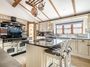 a kitchen with white cabinets and a black counter top at High House Barn - Uk36929 in Foulsham