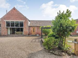 a brick house with a yellow door and a yard at High House Barn - Uk36929 in Foulsham