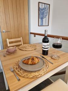 een tafel met een bord eten en een fles wijn bij The Crows Nest - Sheringham in Sheringham