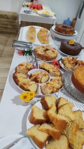 a table topped with plates of food and pies at Pousada Ponta da Baleia in Barra Grande
