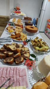 a table with many different types of cakes and desserts at Pousada Ponta da Baleia in Barra Grande
