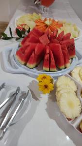 a table with two plates of watermelon and sliced fruit at Pousada Ponta da Baleia in Barra Grande