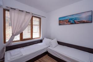 Къща за гости Димови في سوزوبول: غرفة معيشة مع أريكة ونوافذ