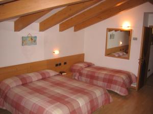 Un pat sau paturi într-o cameră la Dolomiti Hotel Olimpia +24 fotografii