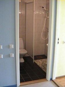 a bathroom with a toilet and a glass shower at Kuressaare Airport Guest House in Kuressaare