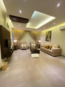 un ampio soggiorno con divani e TV di ريحانة 2 - Raihana 2 Hotel a Gedda