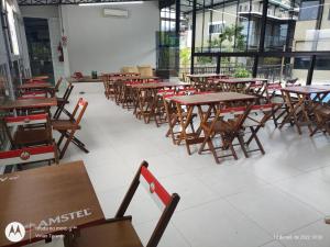 uma fila de mesas e cadeiras numa cafetaria em FRANCIS HOTEL MAR em Caraguatatuba
