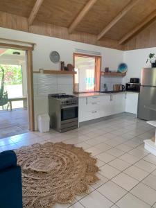 a large kitchen with white appliances and a rug at Konini Villa in Rarotonga