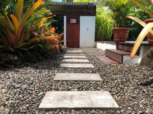 a garden with a pathway leading to a shrine at Alloro Jungle Villas in Puerto Viejo