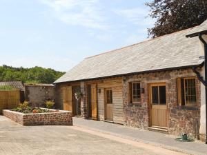 a small stone building with a garage at The Bothy - UKC3549 in Holcombe Burnell