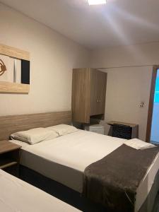 Habitación de hotel con 2 camas y armario en Hotel Imperador, en Santos