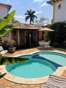 a swimming pool in front of a house at Pousada Ouro de Minas in Tiradentes