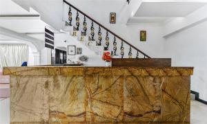 a living room with a wooden counter and stairs at Treebo Trend B Coral 2 Km From Promenade Beach in Pondicherry