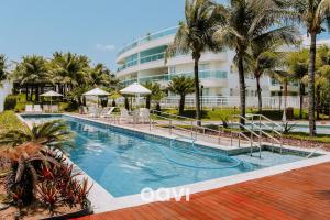 uma piscina em frente a um hotel em Qavi - Flat com Jacuzzi em Resort Beira Mar Cotovelo #InMare7 em Parnamirim
