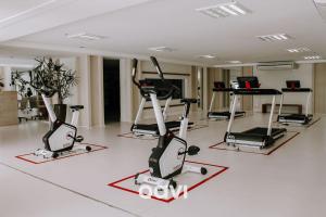 einen Fitnessraum mit Laufbändern und Crosstrainern in einem Zimmer in der Unterkunft Qavi - Flat com Jacuzzi em Resort Beira Mar Cotovelo #InMare7 in Parnamirim