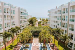 uma vista aérea do pátio de um edifício com palmeiras em Qavi - Flat com Jacuzzi em Resort Beira Mar Cotovelo #InMare7 em Parnamirim