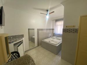 uma casa de banho com uma banheira, um lavatório e um chuveiro em Hotel Bom Gosto em Salvador