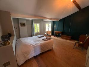 een slaapkamer met een wit bed en een houten vloer bij La Garenne Saint Germain in Saint-Germain-de-Marencennes