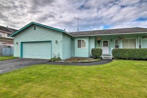 una casa verde con garaje en un patio en Quaint Ranch Home with Yard in Midtown Anchorage! en Anchorage