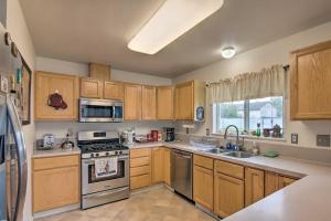 una cocina con armarios de madera y electrodomésticos de acero inoxidable en Quaint Ranch Home with Yard in Midtown Anchorage! en Anchorage