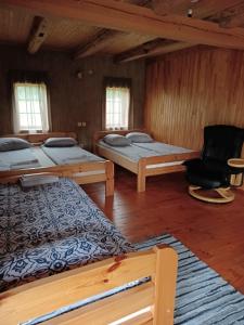 ein Zimmer mit 3 Betten und einem Stuhl darin in der Unterkunft Putraimi. in Princmuiza