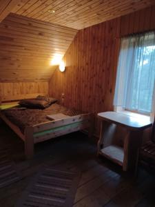 ein Schlafzimmer mit einem Bett in einem Holzzimmer in der Unterkunft Putraimi. in Princmuiza